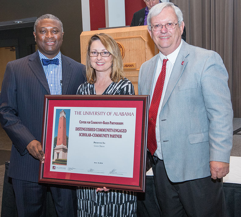 Cindy Dixon of Holt High School receives the Distinguished Community-Engaged Scholar-Community Partner category for her contributions to several Holt projects. Community Affairs Director Samory Pruitt, left, and Interim Dean Joe Benson made the presentation.