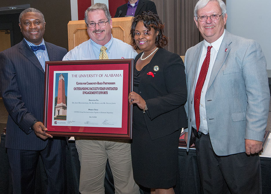 Dr. John Higginbotham and Felecia Jones receive their award for Outstanding Faculty/Staff-Initiated Engagement Effort from Dr. Samory Pruitt, far left, and Interim Provost Joe Benson, far right. Dr. Kim Bissell is also an investigator in the project.