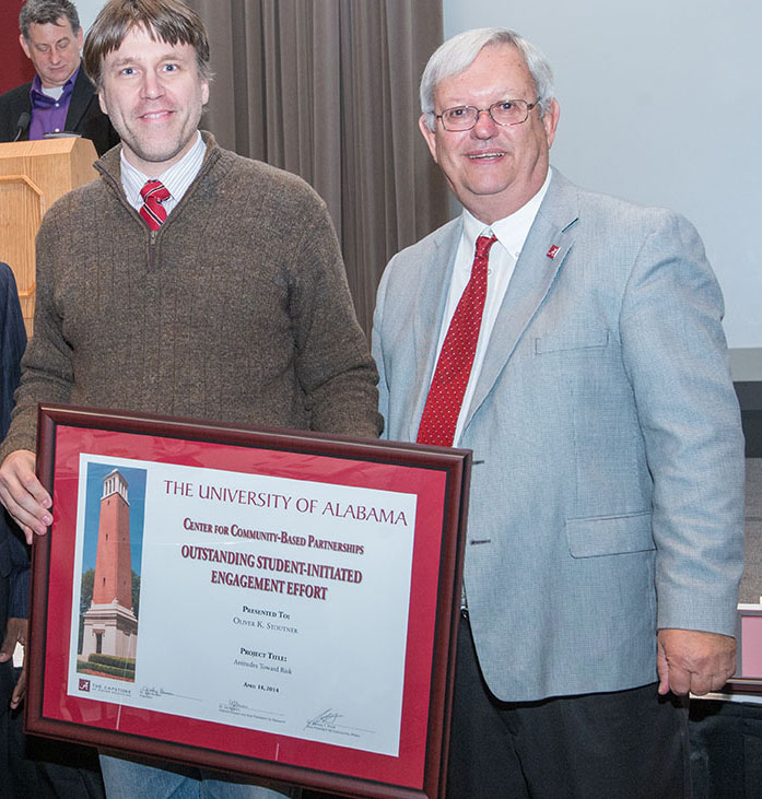 Oliver K. Stoutner, a doctoral student in Management and Marketing, receives his Outstanding Student-Initiated Engagement award from Interim Provost Joe Benson.