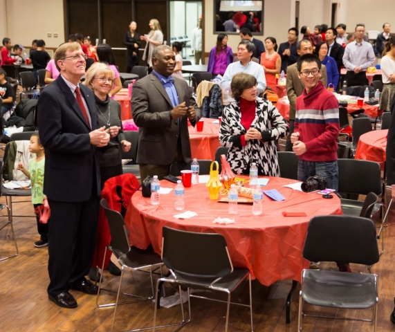 Attendees follow along with the Chinese New Year performers. From left, Dr. Jim McLean, Sharon McLean, Dr. Samory T. Pruitt, Lane McLelland and Jianlong Yang.
