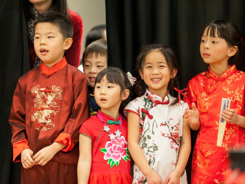 As they await their turn to perform, these children watch the Dragon Dance.