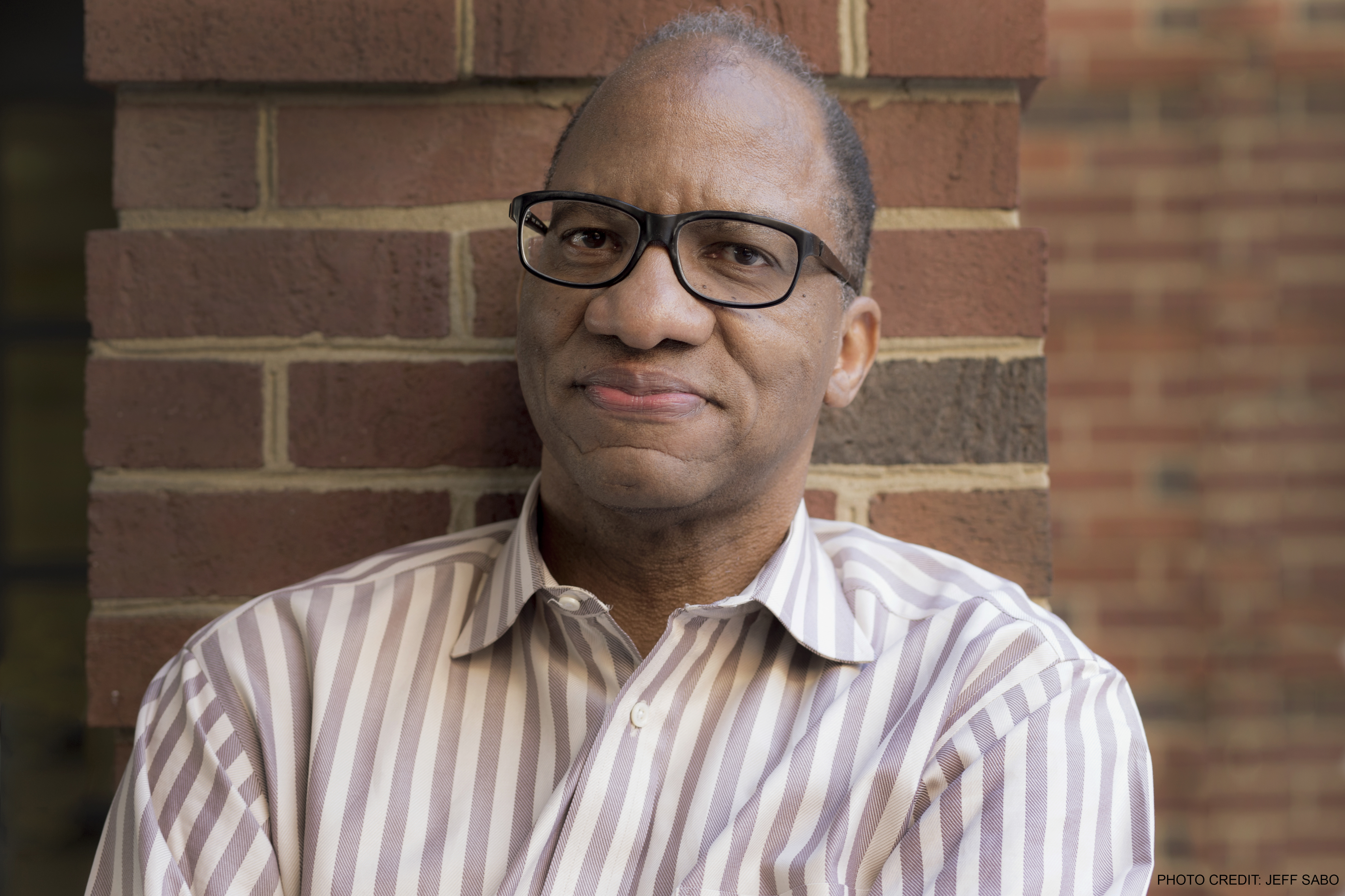 Man standing in front of brick wall