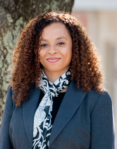 Headshot of Dr. Heather Pleasants wearing a dark blazer and patterned scarf