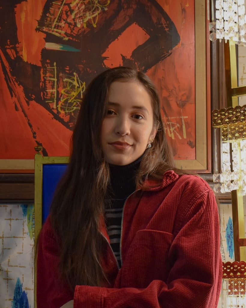 Headshot of Leona Yeager wearing a fluffy red pull over