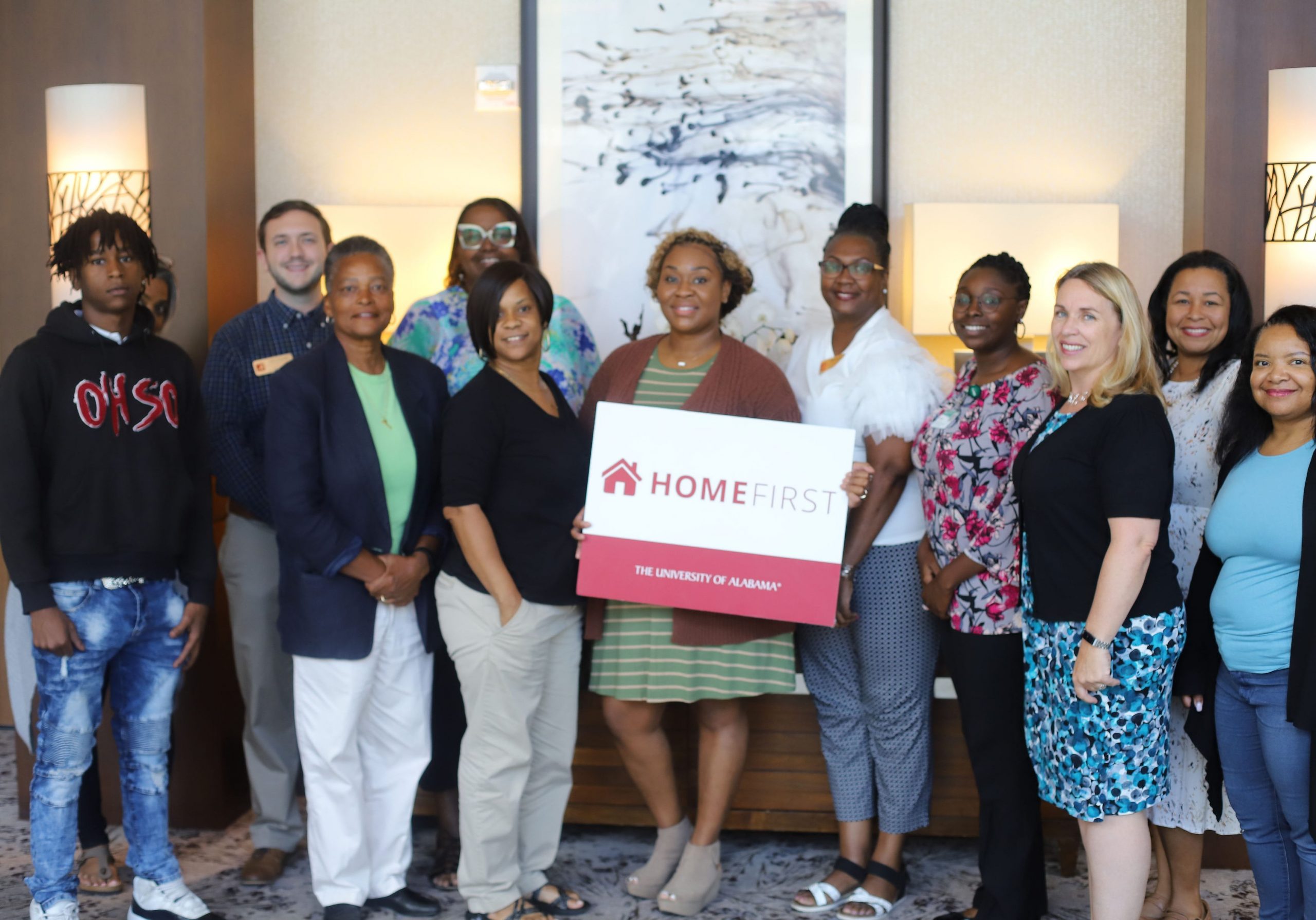 Group of women standing together holding the HomeFirst sign