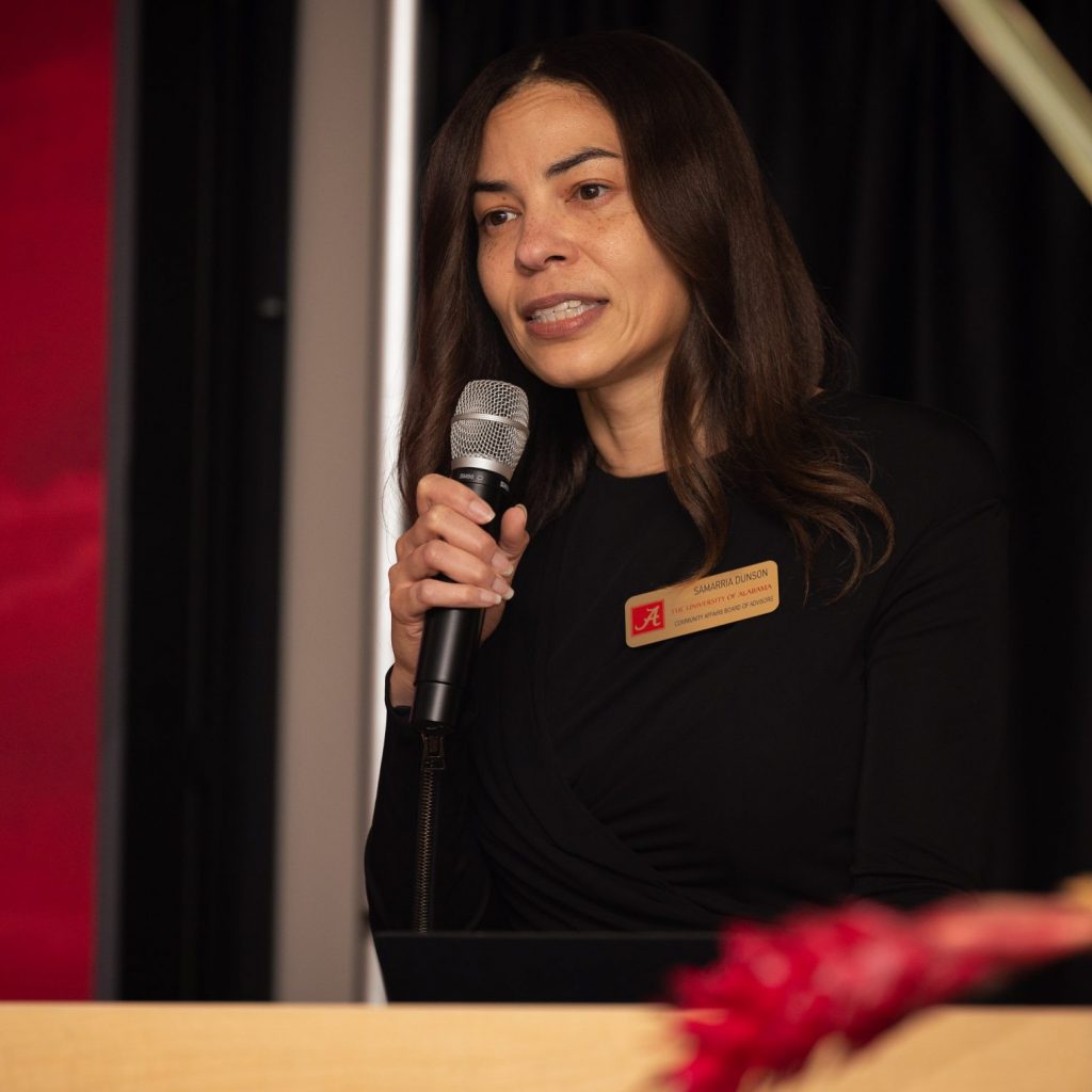 Woman talking into a microphone at a podium