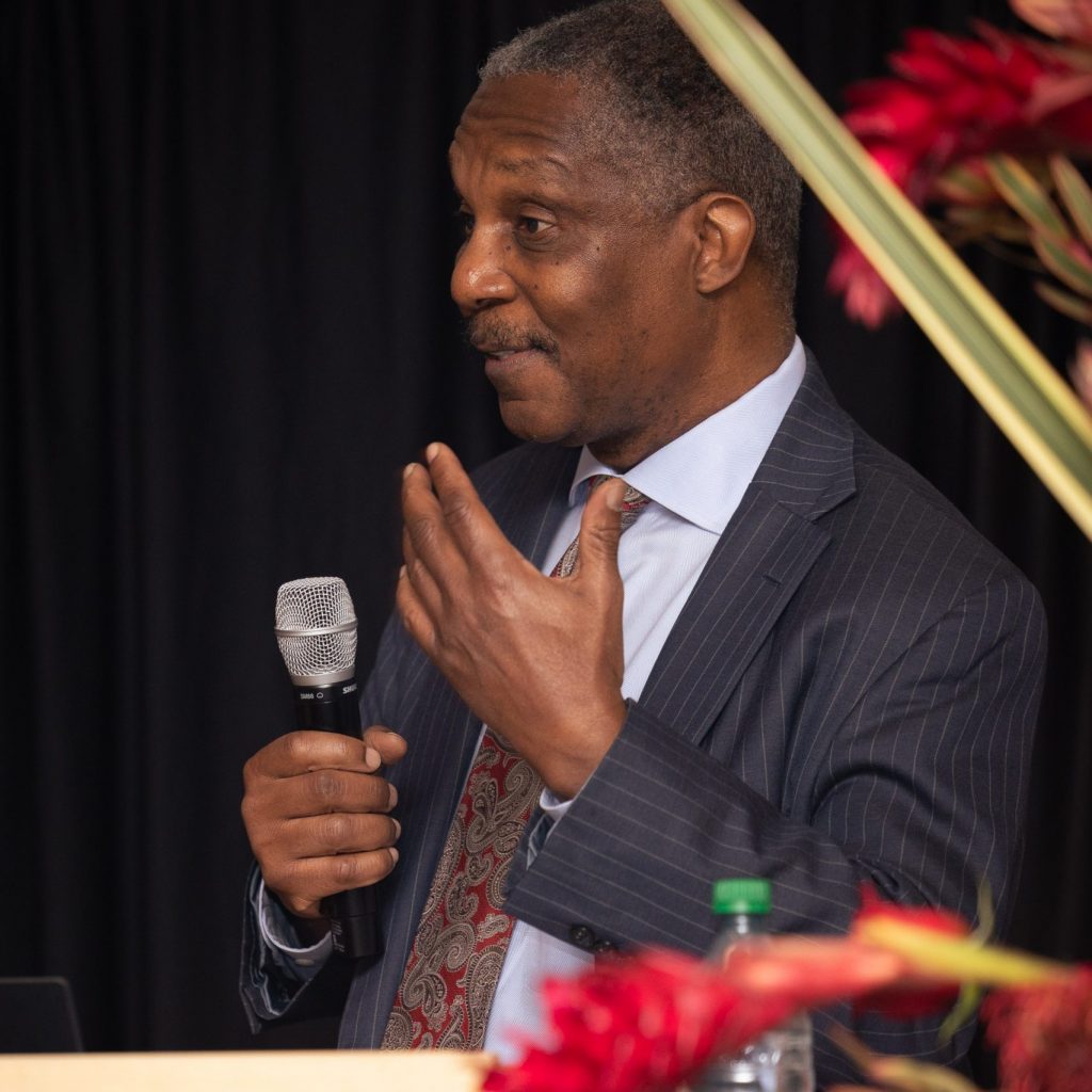 Man talking into microphone at a podium