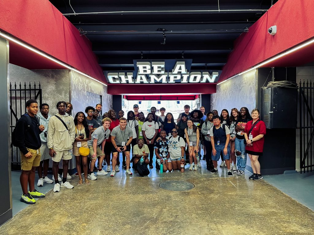 Group of students standing in front of Be A Champion sign