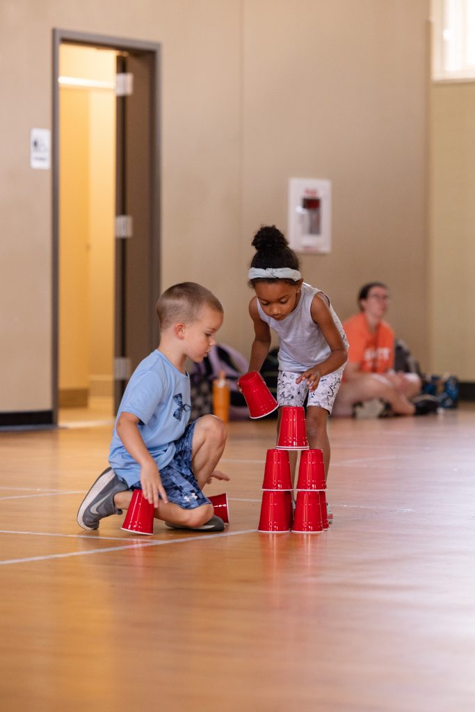 Young boy and girl playing with red solo cups