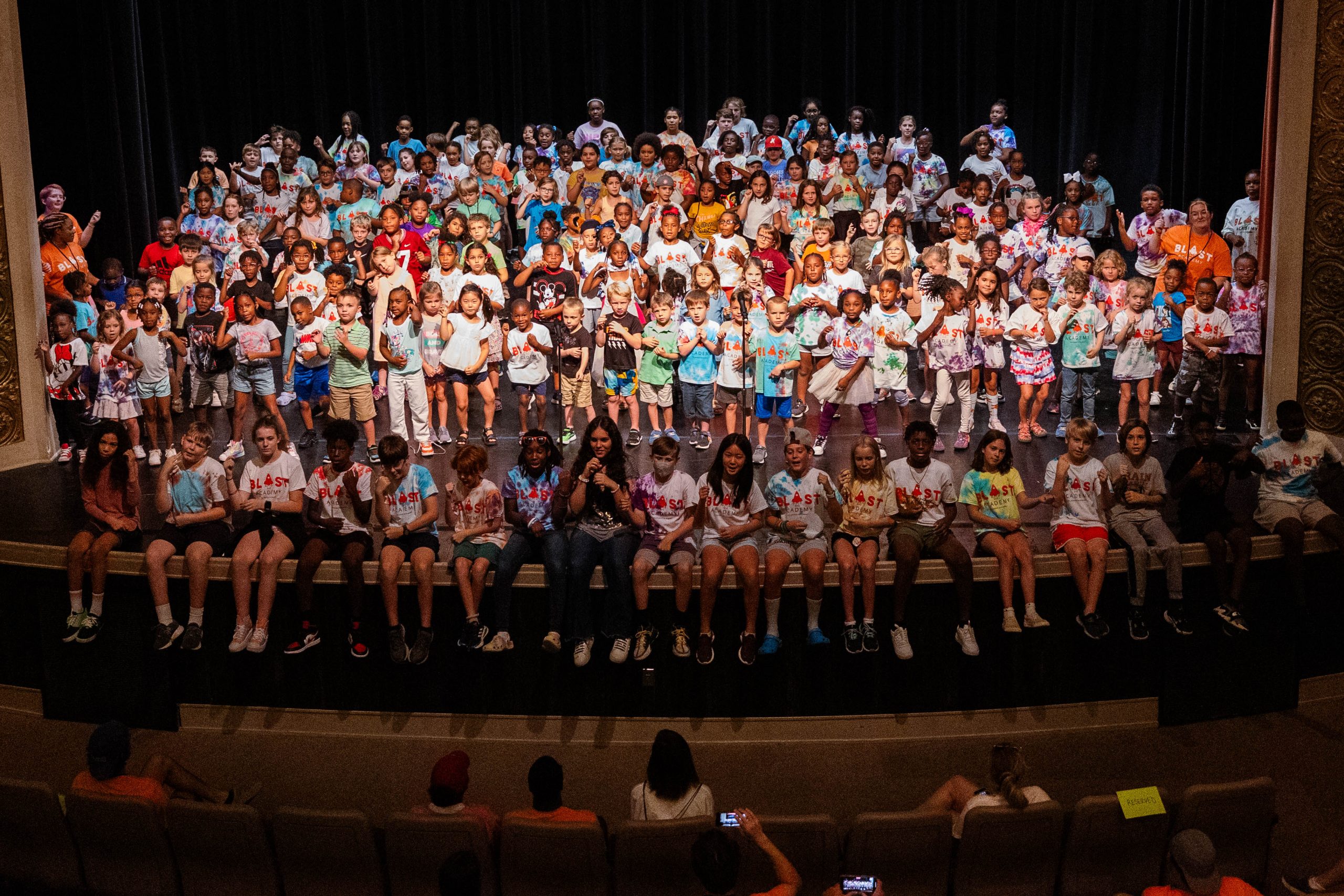 Group of young students sitting and standing on a stage