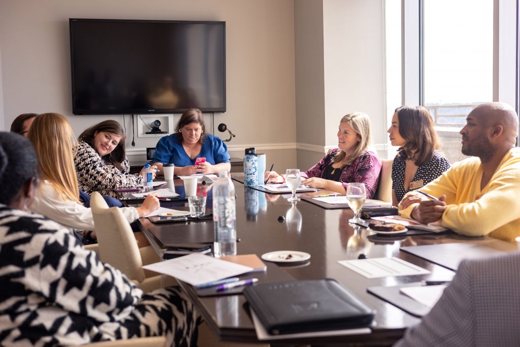 Group of men and women talking at a board room table