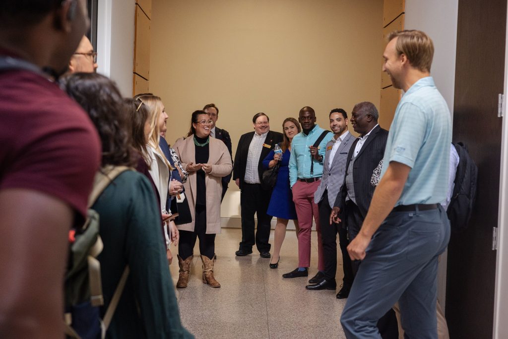 Group of men and women standing in a circle while talking