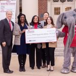 Group of people holding a large check with Big Al