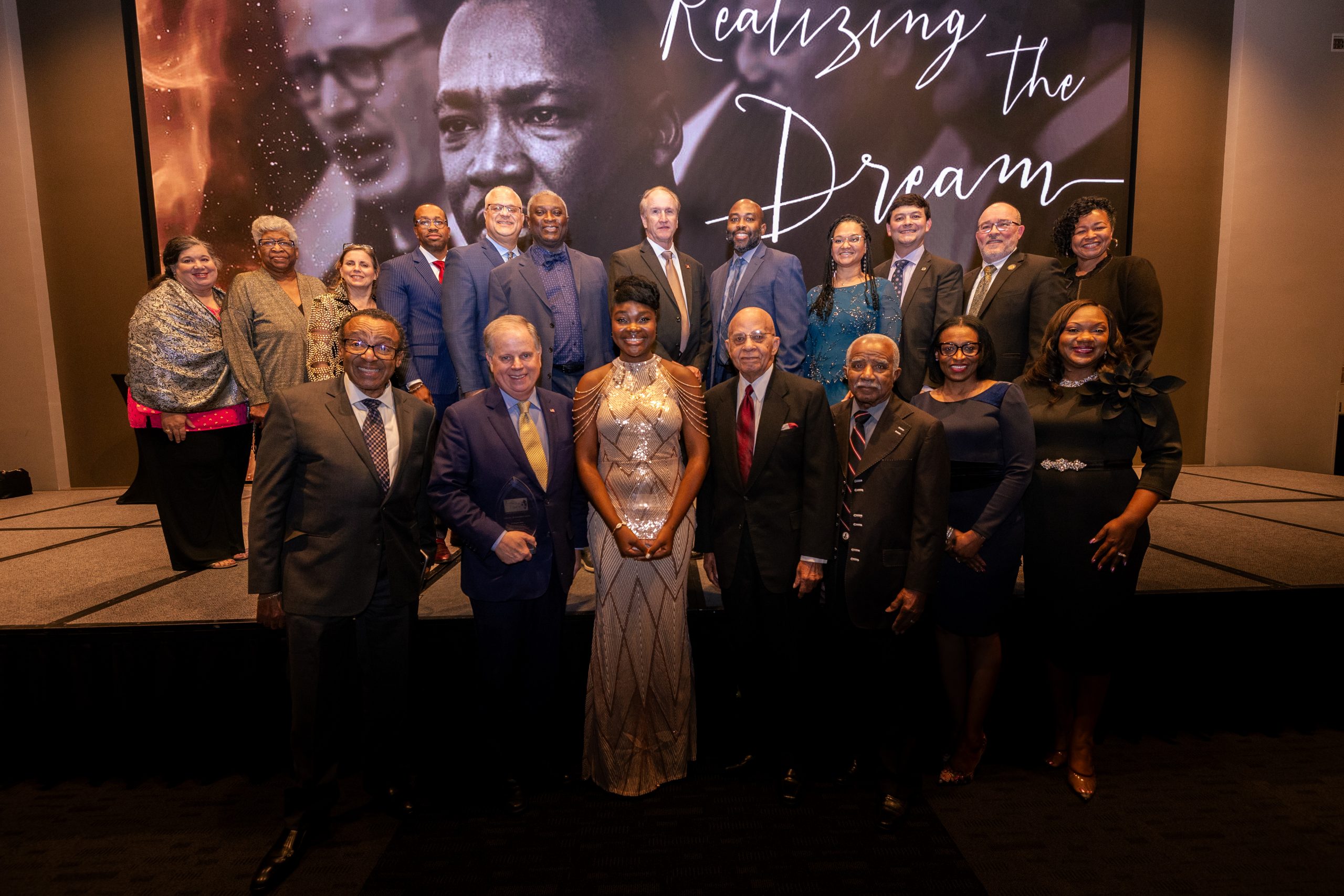 Group of men and women dressed in suits and dresses