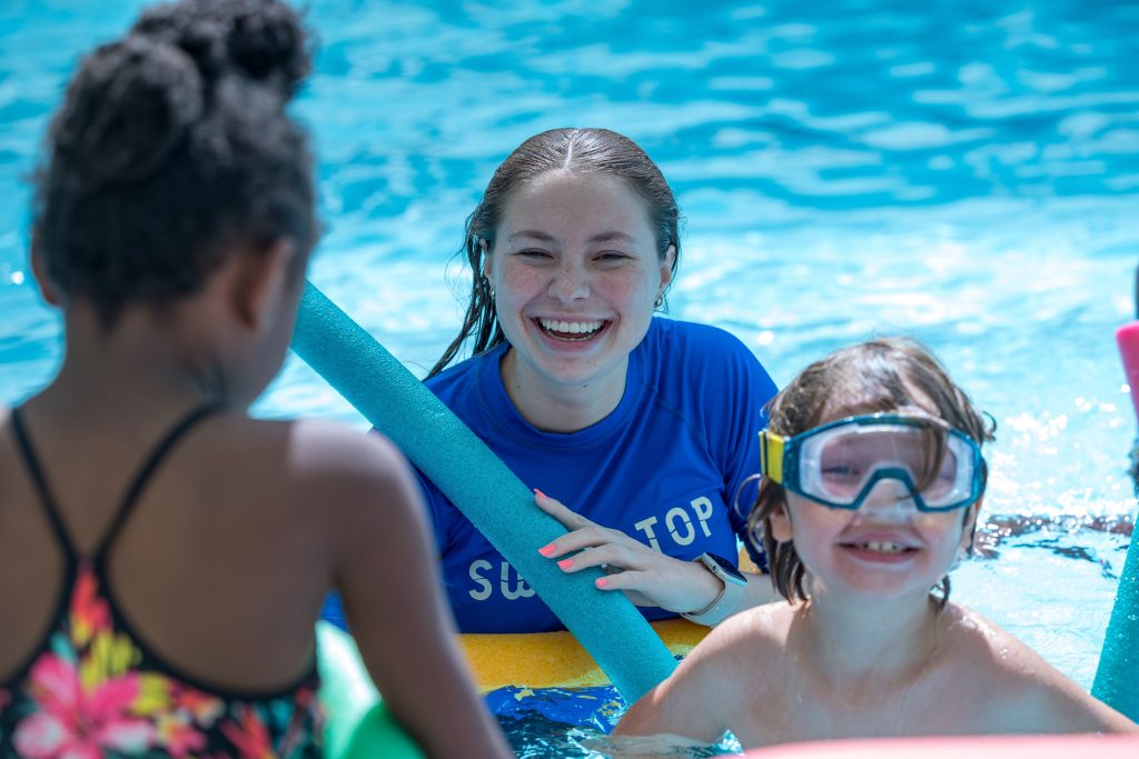 Kids smiling and swimming in a pool