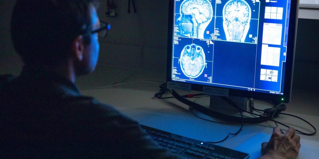 Person using a computer showing scans of someone's brain