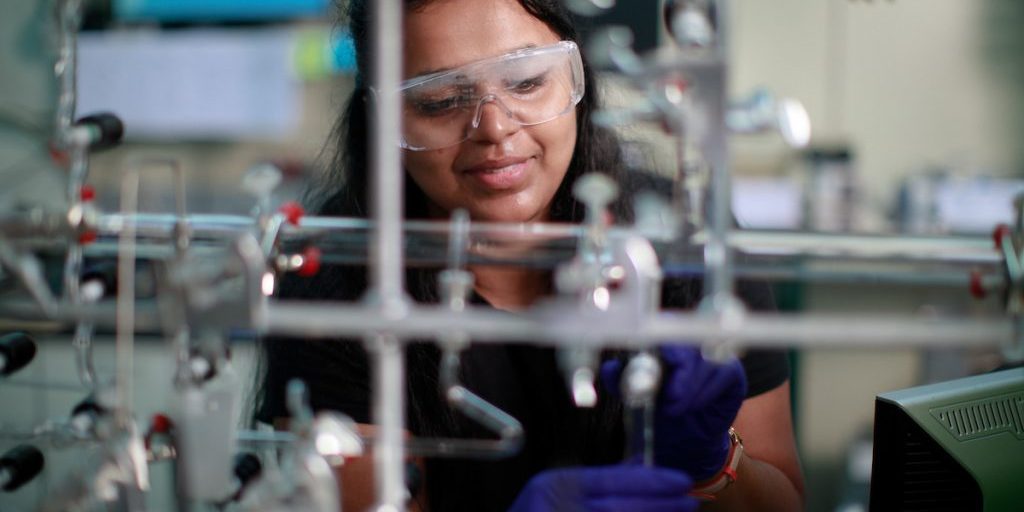 Person working in a chemistry lab wearing safety goggles