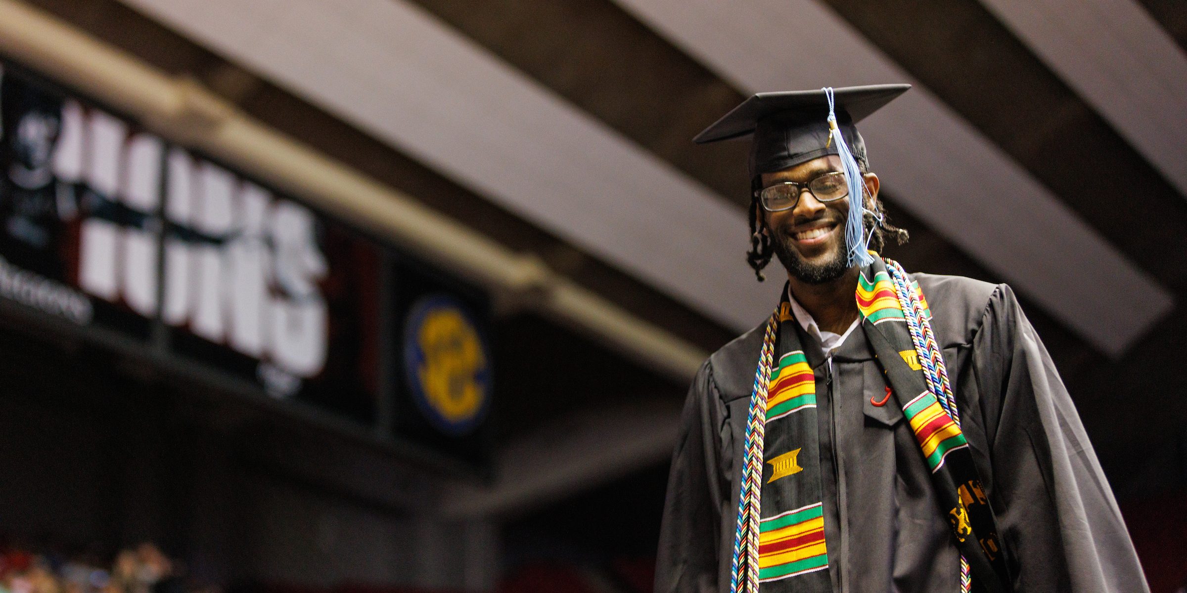 Student walking during commencement wearing a cap and gown