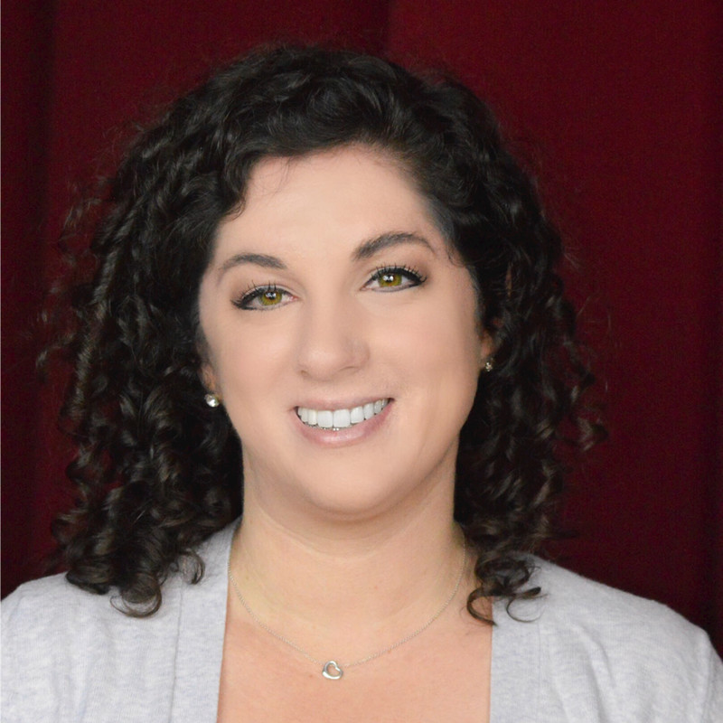 Headshot of Alyssa Dinberg wearing a gray blouse