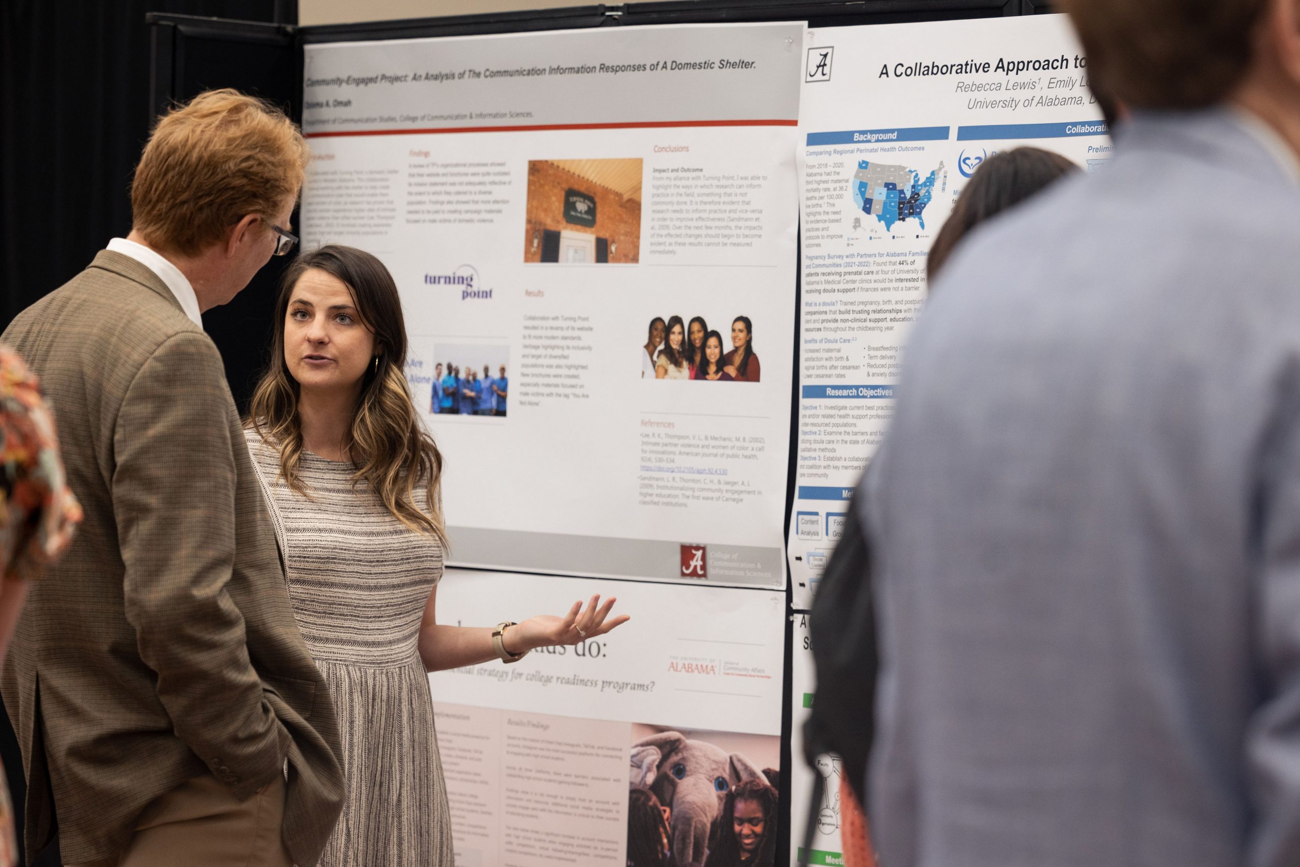 Man and woman talking in front of posters