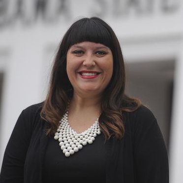 Headshot of Holly McCorkle wearing a black blazer and blouse, and a pearl necklace