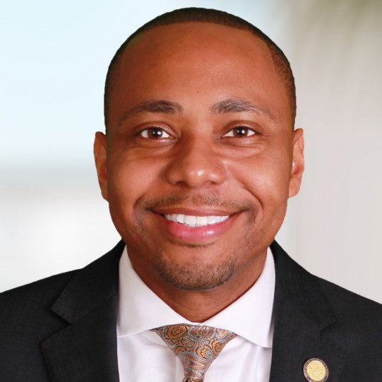 Headshot of Mario Bailey wearing a black suit with a patterned tie