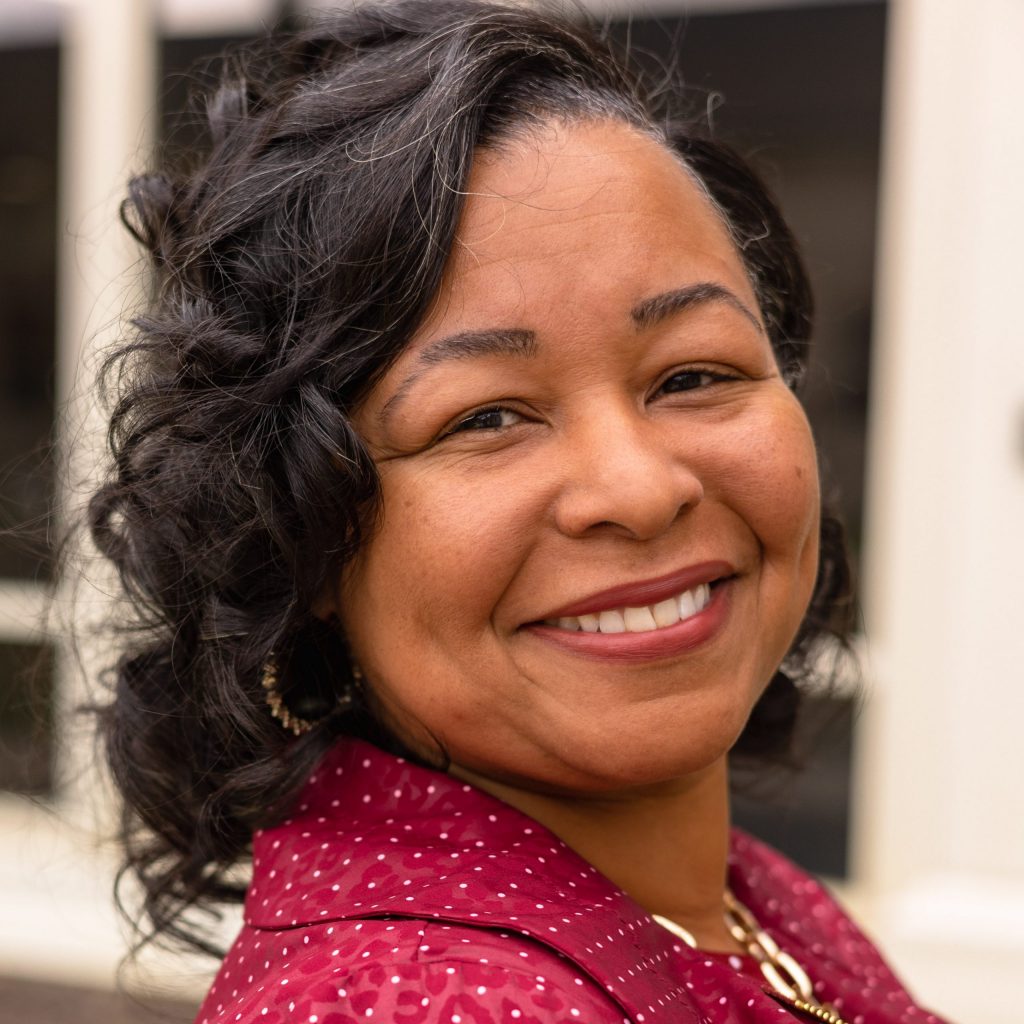 Headshot of Dr. Nicole Prewitt wearing a red collared shirt