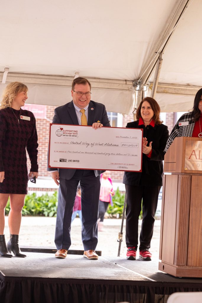 People on stage accepting a large check