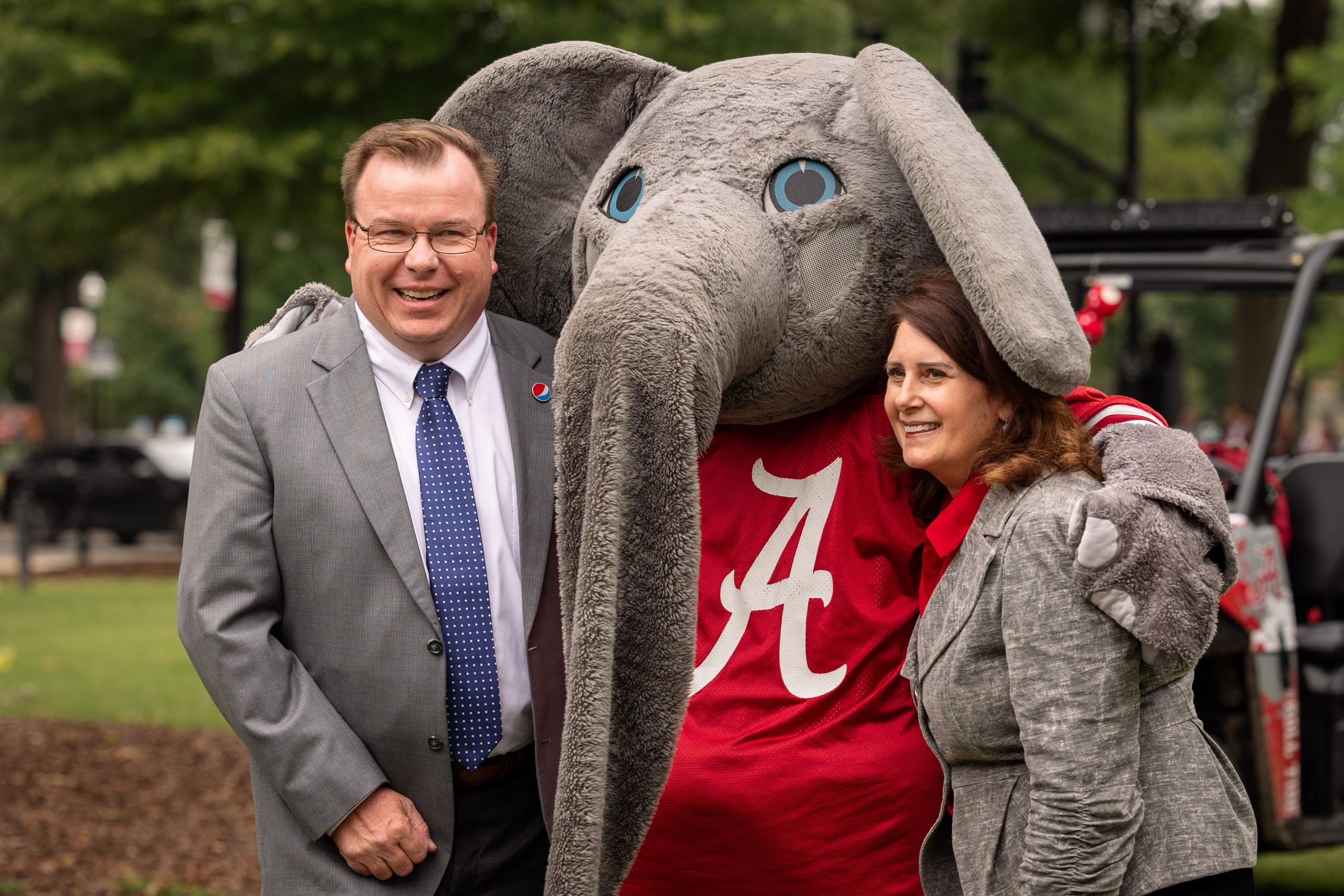 Man, woman, and Big Al posing for a photo together